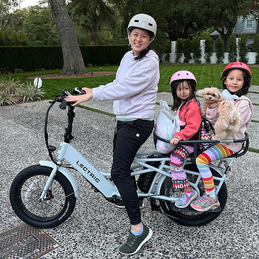 mom riding cargo bike with two girls
