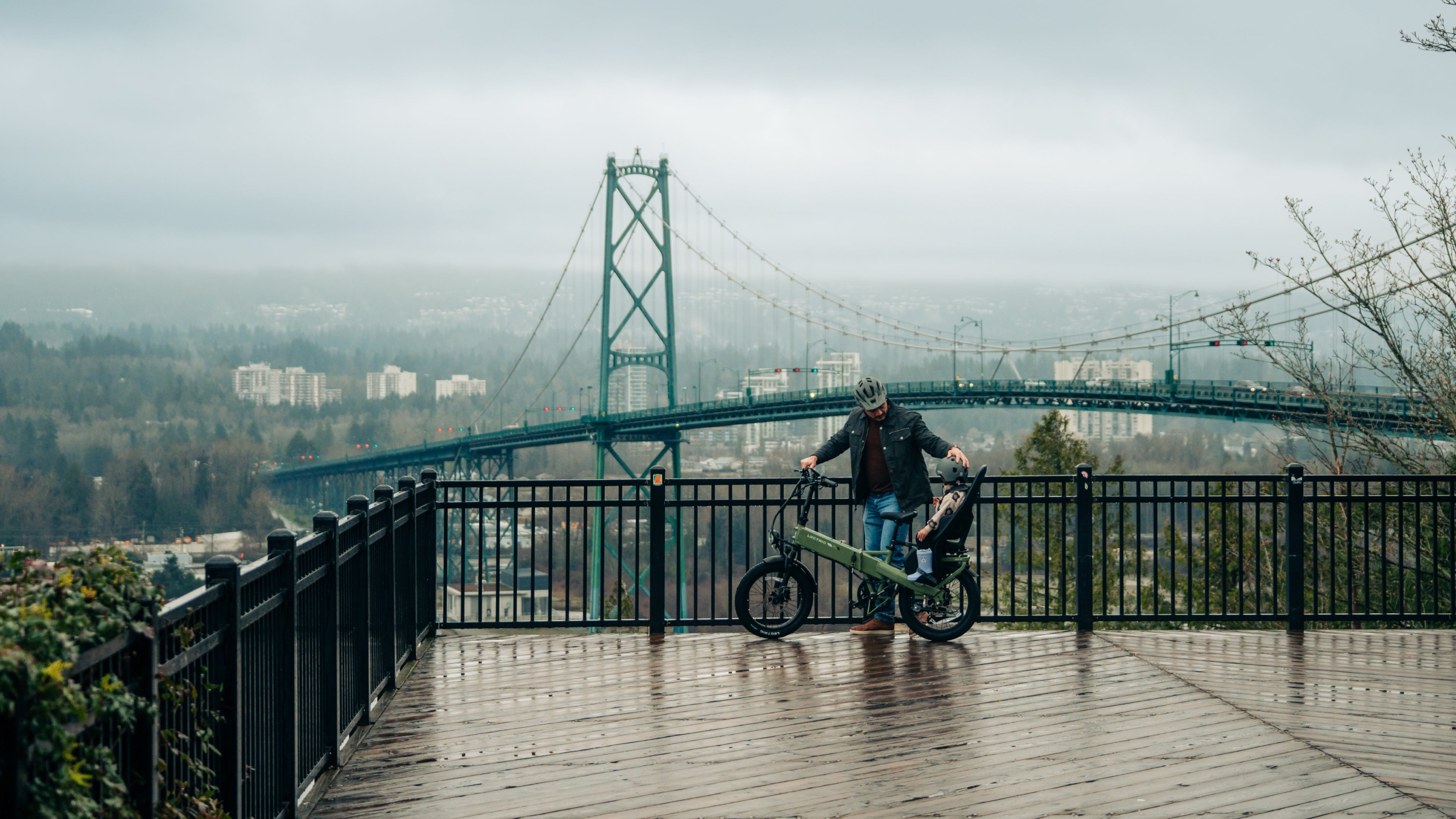 two men riding an ebike on a hill smiling