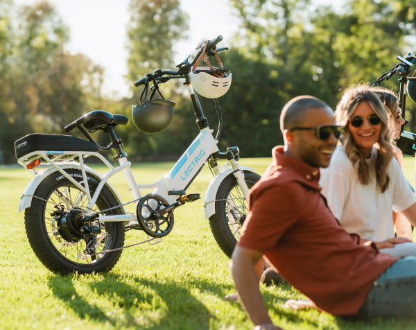 couple sitting by Lectric XP 3.0 Step-Through White eBike
