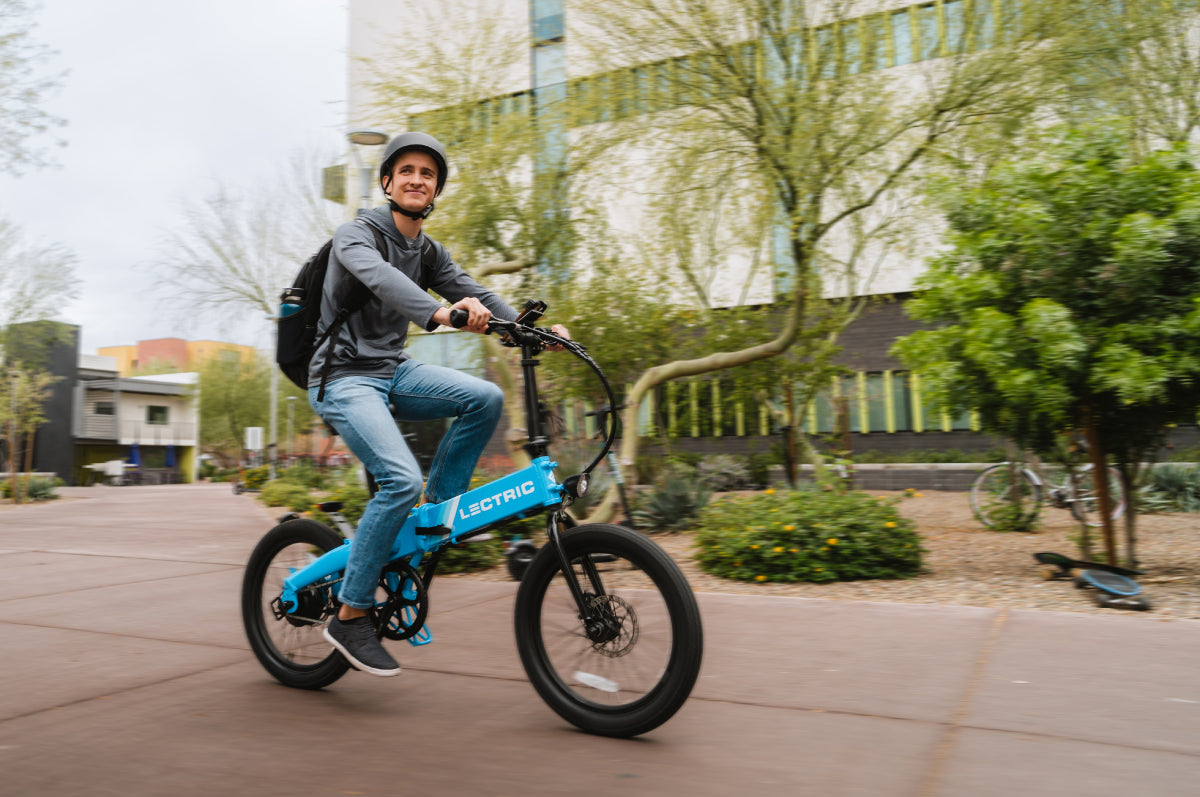 wide image of college student riding Lectric XP Lite eBike on a college campus