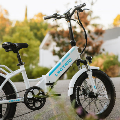 a side-view of a partial White XP Step-Thru 3.0 eBike outside with an autumn background