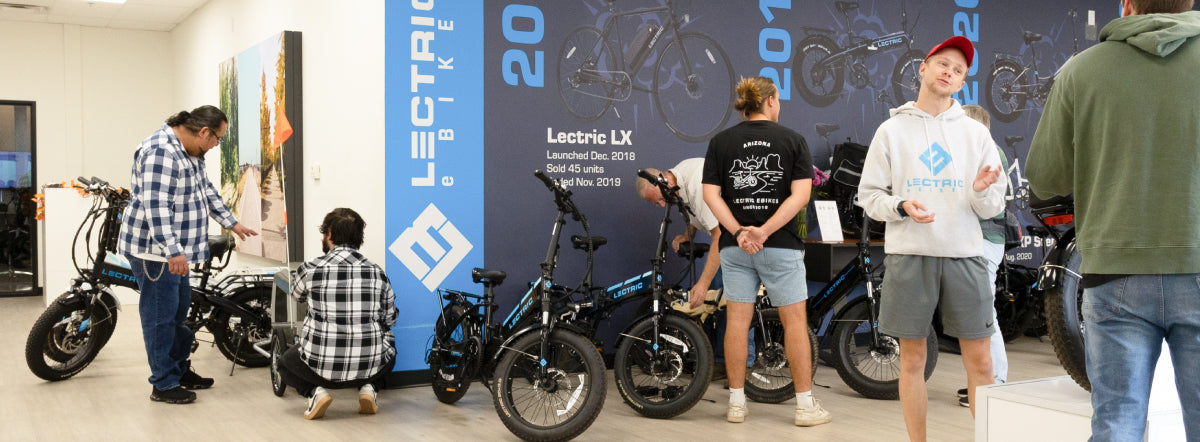 A busy showroom is full of customers and associates discussing Lectric eBikes