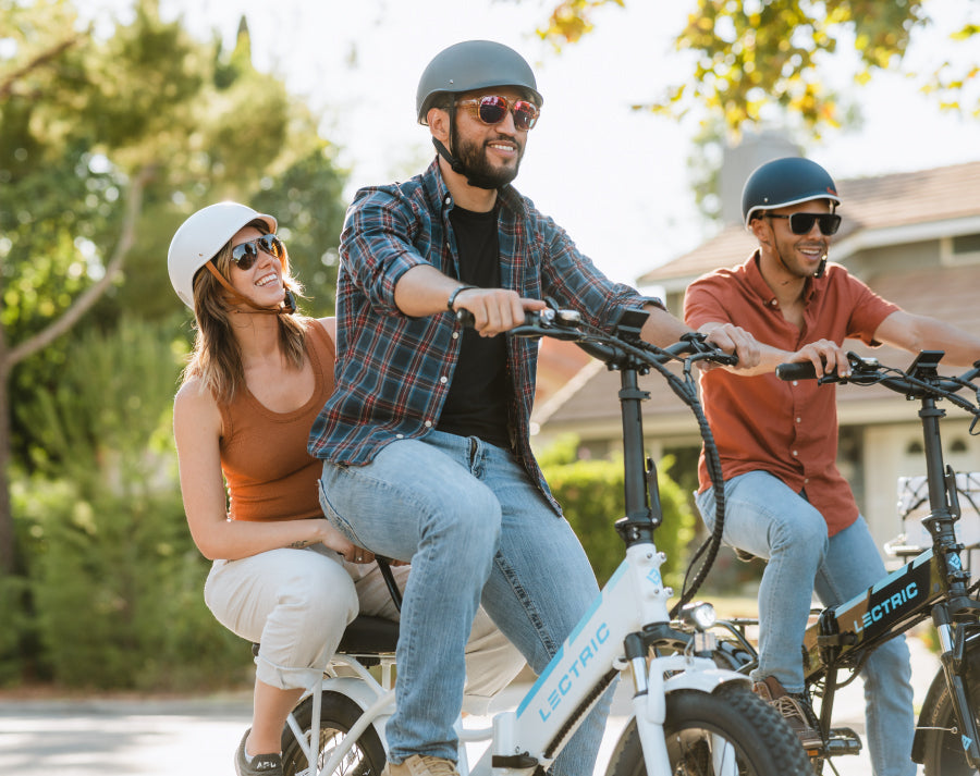 Couple riding a Lectric XP 3.0 Step-Through White ebike and a man riding a Lectric XP 3.0 Black ebike