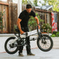 Man folding 1.0 Arctic XP Lite while handlebars are folded with American flag on back