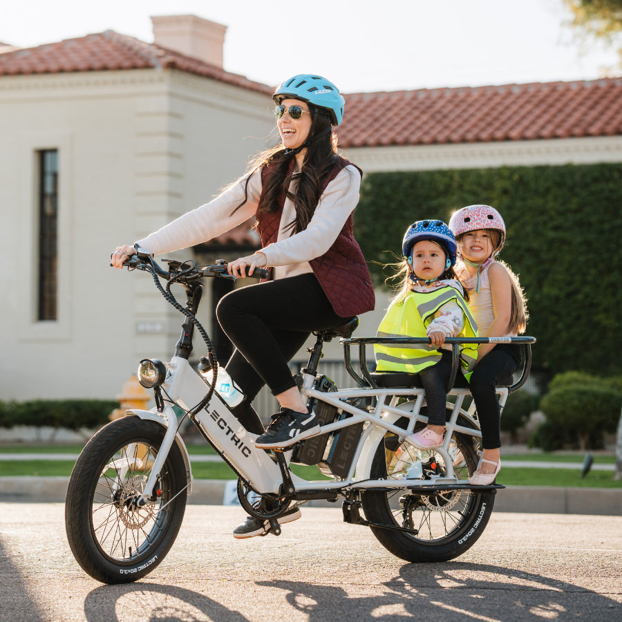 Mom riding a Lectric XPedition cargo ebike with two children riding on the back of bike in an orbitor