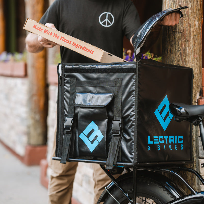 MAN PLACING PIZZA ONTO LECTRIC LARGE FOOD DELIVERY PACKAGE