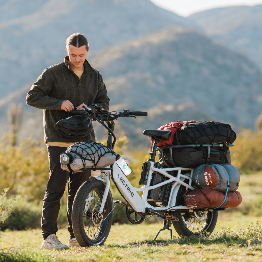 man at campsite with lectric xpedition ebike mounted with cargo