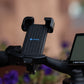 black phone mount next to lcd display on the handlebars of a class 3 ebike in front og blurry flowers