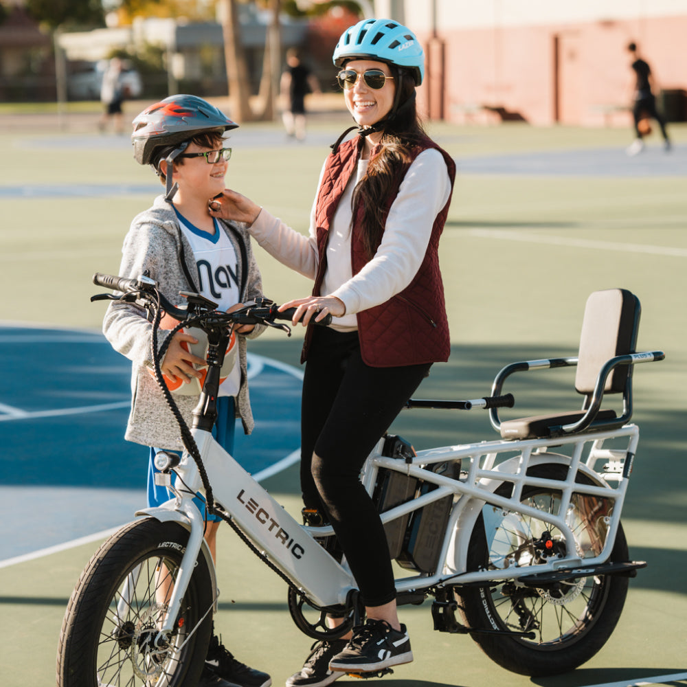Mom talking to son on basketball court while riding dual-battery XPedition cargo ebike with plus 1 sale and barrow bar